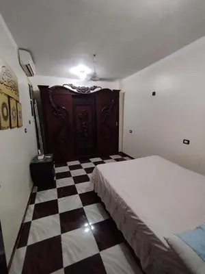 a bedroom with a bed and a checkered floor at Couple's Cove in Luxor