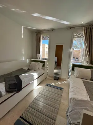 a bedroom with two beds and a large window at Bright & Lovely 2 Beds Apartment in Scarab Club, El Gouna in Hurghada