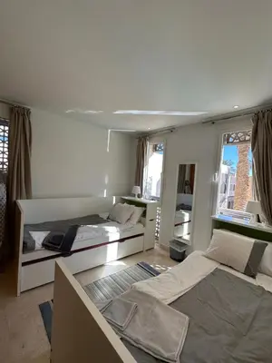 a bedroom with two beds and two windows at Bright & Lovely 2 Beds Apartment in Scarab Club, El Gouna in Hurghada