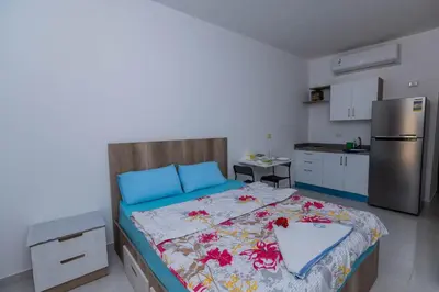 a bedroom with a bed and a kitchen with a refrigerator at La bonita studio in Hurghada