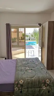 a bedroom with a bed and a view of a pool at La bonita studio in Hurghada