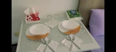 a table with two plates and spoons on a bed at La bonita studio in Hurghada