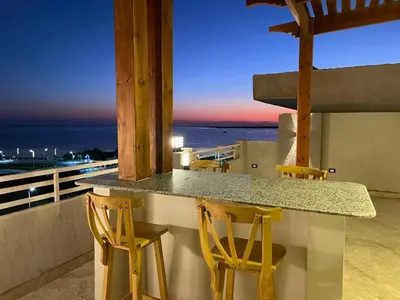 a kitchen with a counter and two stools at Divers Home Safaga in Safaga