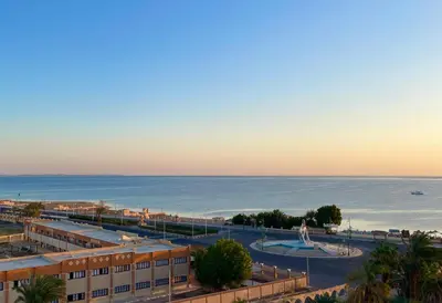 a view of the beach and the ocean at sunset at Divers Home Safaga in Safaga