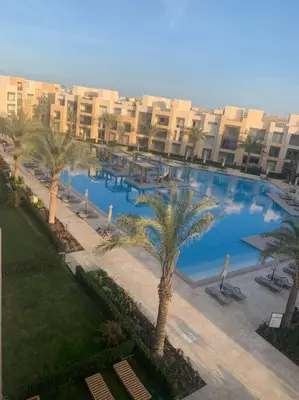 an overhead view of a large swimming pool with palm trees at Mangroovy - 2BR Prodigious Ground Pool & Sea view in Hurghada
