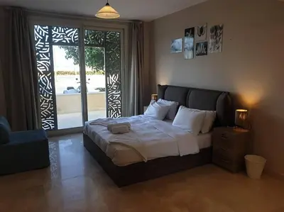 a bedroom with a bed with a teddy bear on it at Mangroovy - 2BR Prodigious Ground Pool & Sea view in Hurghada