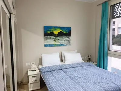 a bedroom with a bed and a painting on the wall at Mangroovy- 1BR Sea Breeze Back Sea view in Hurghada