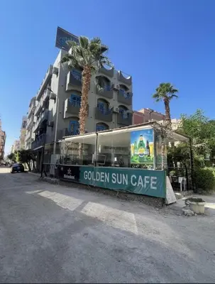 a building with a sign that reads golden sun cafe at فندق جولدن صن العروسه طريق الشيراتون السقالة ميدان محافظة البحر الأحمر 84511 مصر in Hurghada