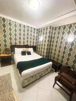 a bedroom with a bed and a chair in it at فندق جولدن صن العروسه طريق الشيراتون السقالة ميدان محافظة البحر الأحمر 84511 مصر in Hurghada