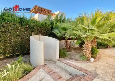 a garden with palm trees in front of a house at Unique Villa 6 B Rooms Villa 38 at El-Gouna in Hurghada