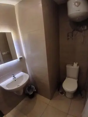 a bathroom with a white toilet and a sink at Hotel Apartment in G cribs in Hurghada