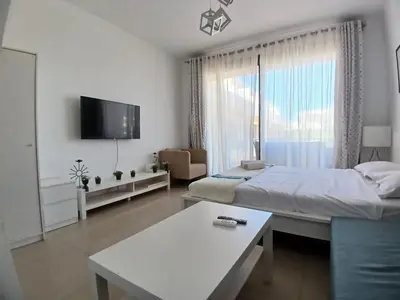 a bedroom with a bed and a table and a tv at Hotel Apartment in G cribs in Hurghada