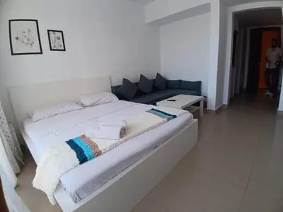 a large white bed in a room with a couch at Hotel Apartment in G cribs in Hurghada