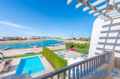 a view of the pool and beach from the balcony of a house at Ollystays Joubal Lagoon 4 BR Villa Heated Pool in Hurghada
