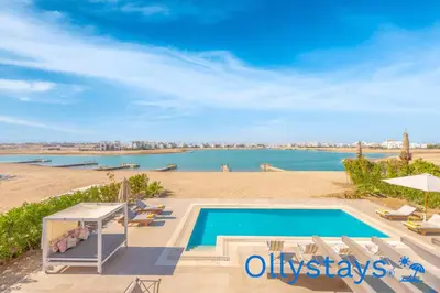 a swimming pool with a view of a body of water at Ollystays Ancient Sands 4 BR Villa Heated Pool in Hurghada