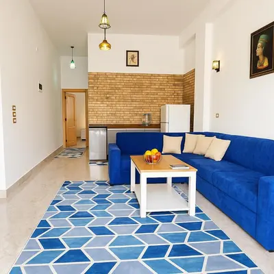a living room with a blue couch and a table at Villa Desert Rose in Luxor