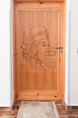 a drawing of a woman on a wooden door at Villa Desert Rose in Luxor