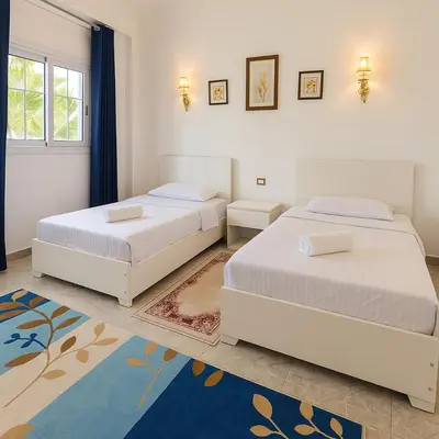 a bedroom with two beds and a rug at Villa Desert Rose in Luxor
