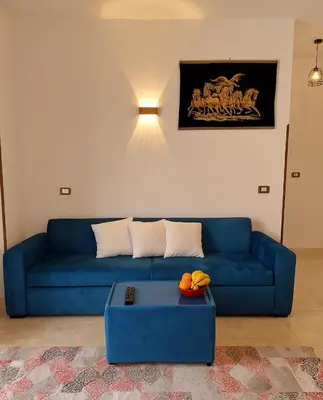 a blue couch in a living room with a table at Villa Desert Rose in Luxor
