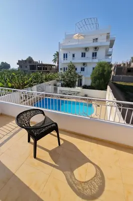 a chair on the roof of a building with a pool at Villa Desert Rose in Luxor