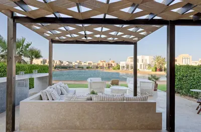 a patio with a couch and chairs under a pergola at Vesta - El Gouna Residence in Hurghada
