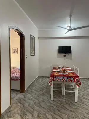 a dining room with a table and a bed at Gîte Hôtel Ramla Louxor 2 in Luxor