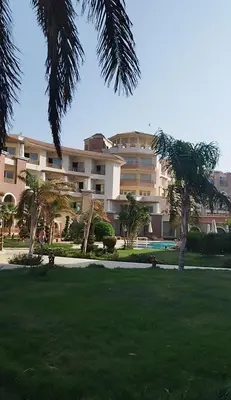 a large building with palm trees in a park at Royal beach resort in Hurghada