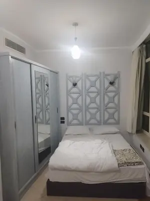 a bedroom with a white bed and a mirror at Royal beach resort in Hurghada