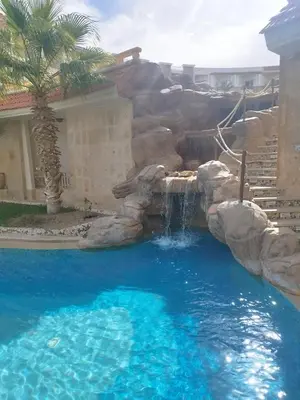 a water slide in a pool with a waterfall at Royal beach resort in Hurghada