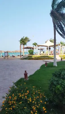 a park with palm trees and flowers on the beach at Royal beach resort in Hurghada