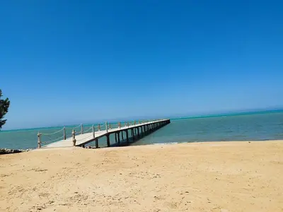 a beach with a pier in the water at Royal beach resort in Hurghada
