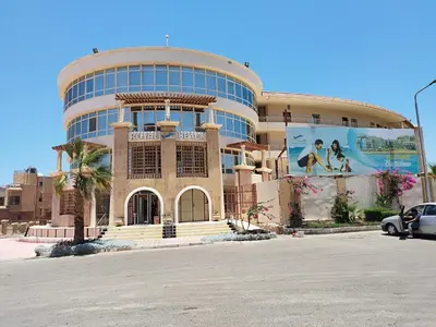 a large building with a billboard on the side of it at Royal beach resort in Hurghada