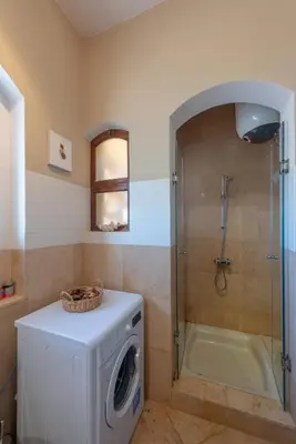 a bathroom with a washing machine and a shower at Soulful 1BR in Italian Compound / Nubia, El Gouna in Hurghada