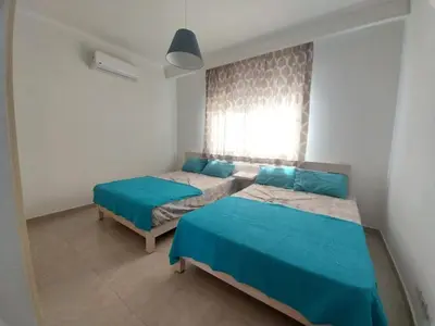 a bedroom with two beds and a window at Relaxing open Seaview Apartment in Hurghada