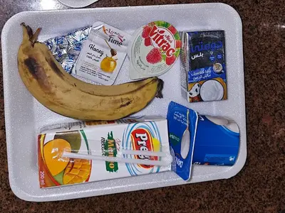 a lunch box with a banana and other food items at Esmerada in Aswan
