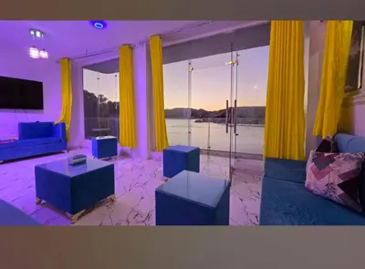 a living room with blue furniture and a large window at Esmerada in Aswan