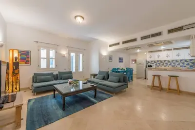 a living room with couches and a table and a kitchen at Abutig Marina flat ground floor in Hurghada