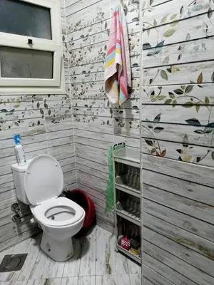 a bathroom with a toilet and a towel at Kazpilkna Beach Neighborhoods in Hurghada