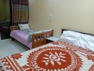 a bedroom with two beds with a red and white blanket at Kazpilkna Beach Neighborhoods in Hurghada