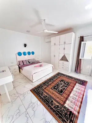 a bedroom with two beds and a rug on the floor at Muhammad Ali House in Luxor