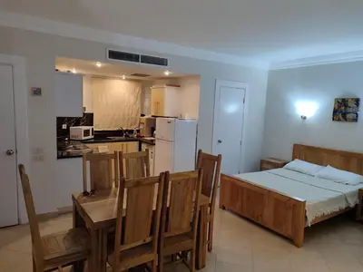 a bedroom with a bed and a table and chairs at Sunset pearl, Sahl Hashish in Hurghada