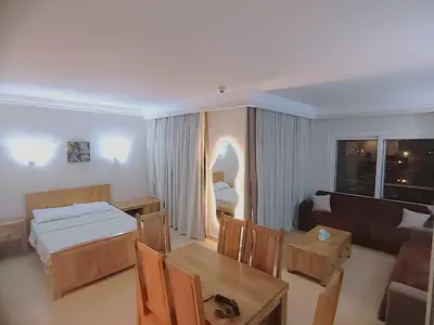 a living room with a bed and a table and a couch at Sunset pearl, Sahl Hashish in Hurghada