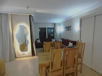 a living room with chairs and a table and a mirror at Sunset pearl, Sahl Hashish in Hurghada