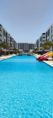 a large pool of blue water in front of buildings at Fanadir Bay Resort in Hurghada