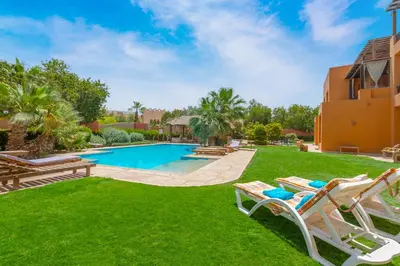 a yard with chairs and a swimming pool at Charming Apartment with Pool in prime location in Hurghada