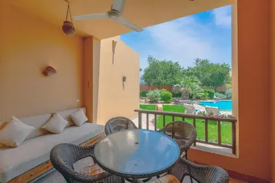 a balcony with a table and chairs and a couch at Charming Apartment with Pool in prime location in Hurghada