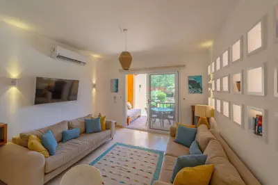 a living room with a large couch and blue pillows at Charming Apartment with Pool in prime location in Hurghada
