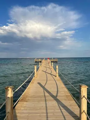 a wooden pier in the middle of the ocean at Apartment with large terrace & nice pool area in Hurghada