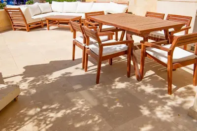 a wooden table and chairs on a patio at Apartment with large terrace & nice pool area in Hurghada