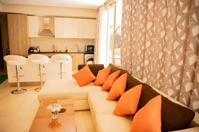 a living room with a couch with orange pillows at Apartment with large terrace & nice pool area in Hurghada
